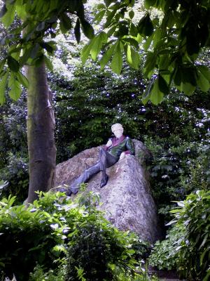 Eine Figur auf einem Stein in einem Park in Dublin, die den Autoren Oscar Wilde darstellt.