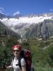 Melanie und im Hintergrund die Damma-Hütte auf dem Berg.