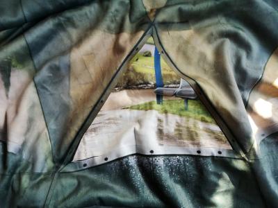 Blanket shows a view out of the window to a piece of gras and bank for relaxation.