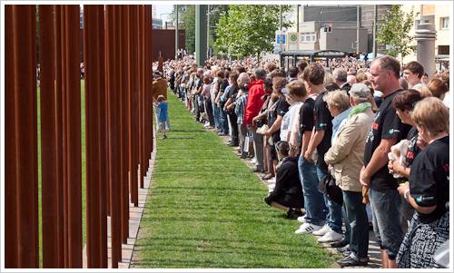 Menschen vor rostigen Stelen Menschen vor rostigen Stelen