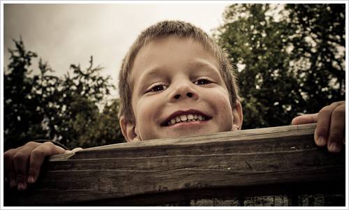 Ein Junge schaut über den Rand eines Spielgerätes Ein Junge schaut über den Rand eines Spielgerätes