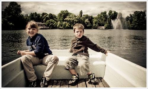 Junge und Mädchen im Heck eines Ruderbootes Junge und Mädchen im Heck eines Ruderbootes