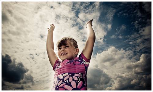 Ein Mädchen vor einem bewölkten Himmel Ein Mädchen vor einem bewölkten Himmel