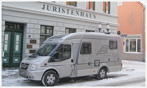 Wohnmobil vor einem Haus