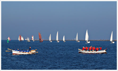 Zwei Kutter vor Segelbooten