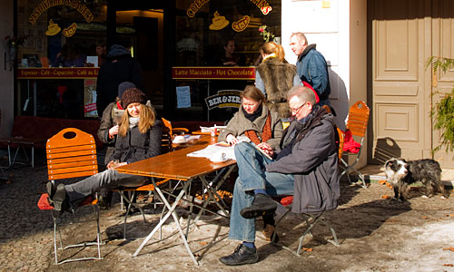 Menschen vor einem Cafe in der Sonne Menschen vor einem Cafe in der Sonne
