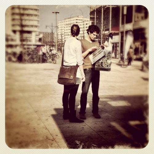 Mann und Frau auf einem Platz studieren einen Stadtplan Mann und Frau auf einem Platz studieren einen Stadtplan