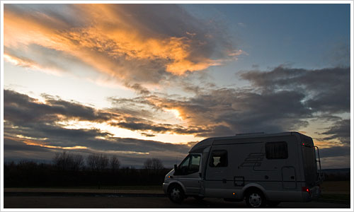 Wohnmobil unter offenem Wolkenhimmel Wohnmobil unter offenem Wolkenhimmel