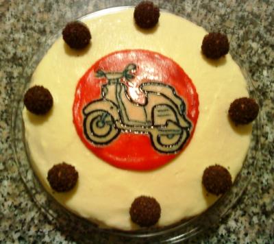 Eine schöne Torte für Jungs. Die Torte hat eine Platte aus Marzipan, auf der eine "Schwalbe" zu sehen ist. Das Geburtstagskind ist ein großer Fan dieses Zweirades. 